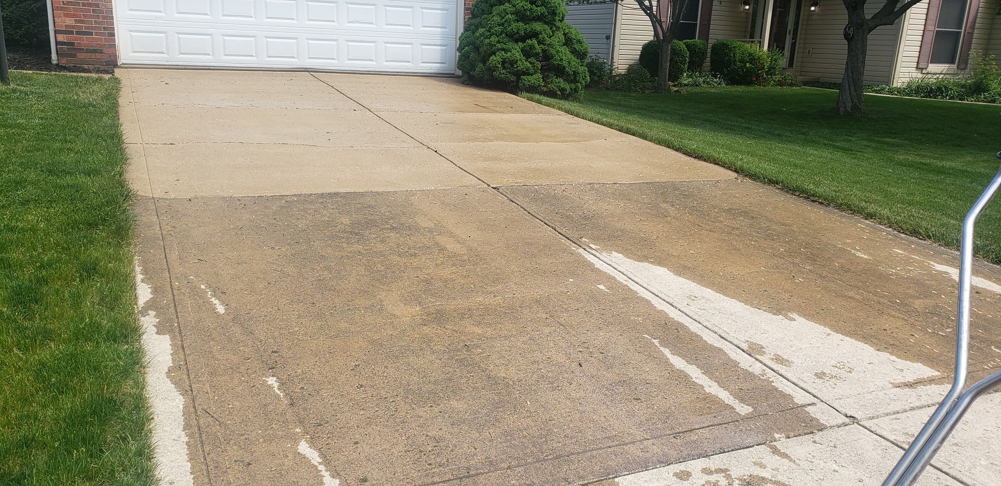 Concrete driveway showing the difference between cleaned and dirty sections